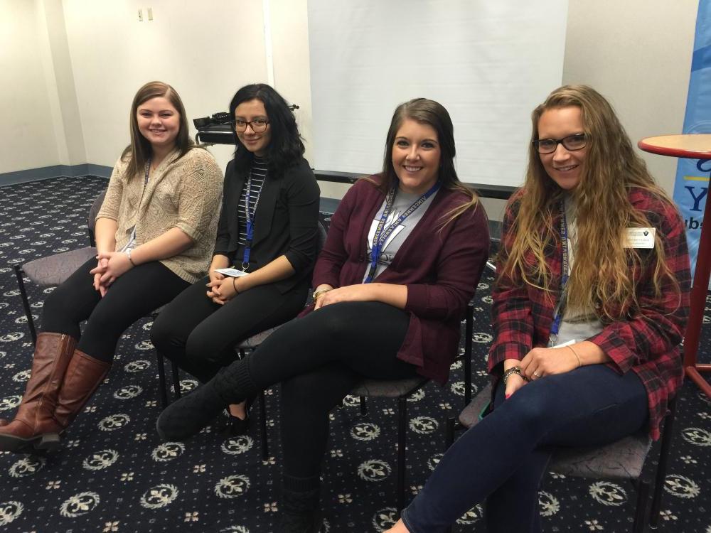 Four women sitting in chairs for a photo